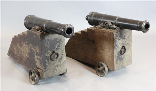 A pair of 19th century bronze signal cannons on stepped oak trunnions, cannons 27in. overall length 36in.